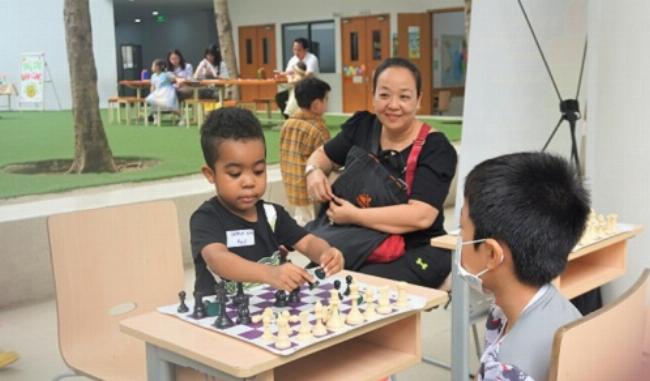 Một người cha đang kiên nhẫn giúp con gái lớp 4 học từ mới tiếng Anh tại nhà