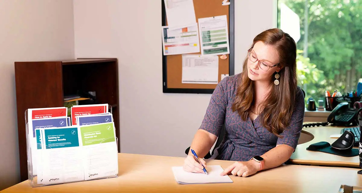 A DigiPen Financial Aid representative doing paperwork on a desk.