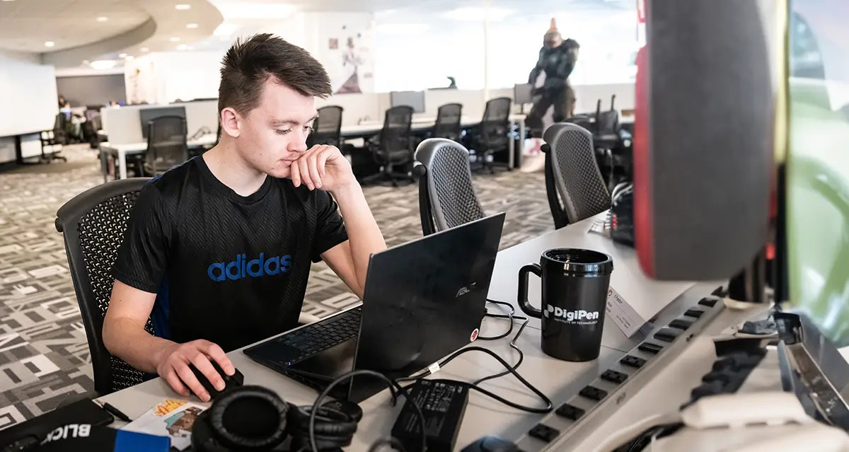 A DigiPen student studying on his laptop in a computer lab.