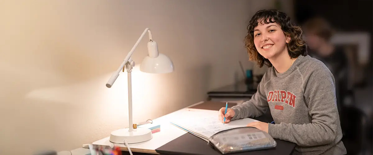 With pencil in hand, a student smiles as she makes progress on her studies.