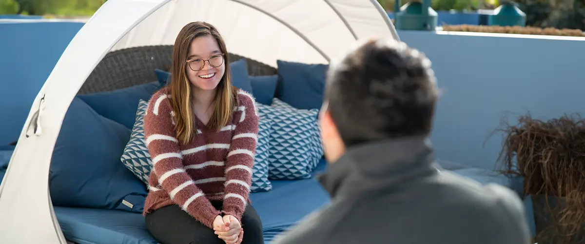 A student eagerly chats with a member of the financial aid team.